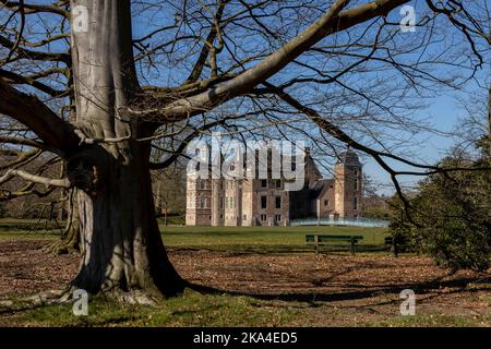 Winter karger Baum und Äste hell mit Backstein Außenfassade des Schlosses Ruurlo und Glas-Zugangsbrücke im Hintergrund