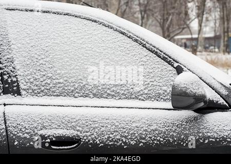 Auto bedeckt mit frischem weißen Schnee an einem Wintertag. Fahrzeug mit Schnee bedeckt Stockfoto