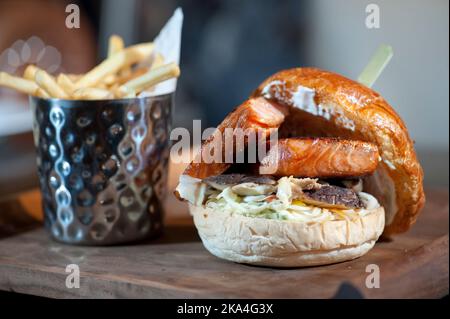 Lachs- und Fleischburger mit gebratenem Französisch Stockfoto