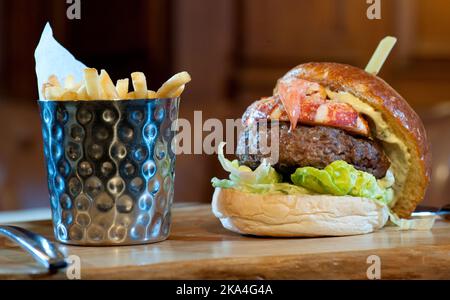 Hummer und Fleischburger werden auf einem Holzbrett serviert Stockfoto