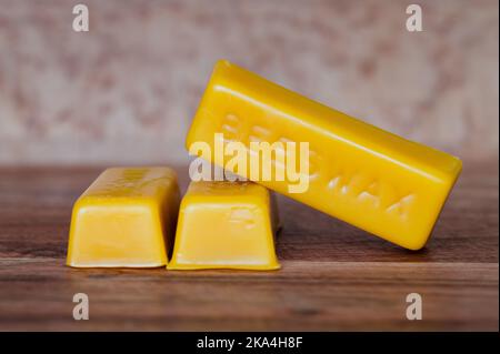 Drei Balken reines Bienenwachs auf Holzhintergrund Stockfoto