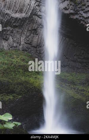 Latourell Wasserfall in Oregon, mit grauer strukturierter Felswand und Moos, die am Ende des Wasserfalls wachsen. Stockfoto