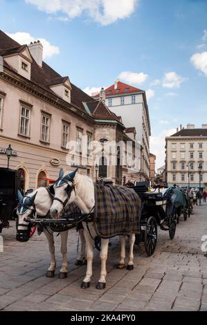 Wiener Fiaker Zweipferdewagen sind Teil der Landschaft der österreichischen Hauptstadt. Stockfoto