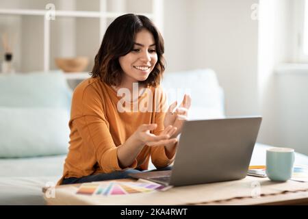 Lächelnde Junge Arabische Freiberufliche Designerin Lady Mit Telekonferenz Auf Laptop Zu Hause Stockfoto