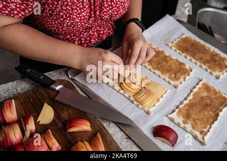 Junge Erwachsene Frauen machen Gebäck mit Äpfeln Stockfoto