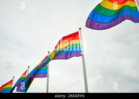 LGBT-Flaggen gegen bewölkten Himmel Stockfoto