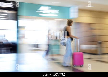 Eine verschwommene Reisende Frau mit einem Koffer Stockfoto
