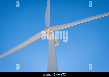 Nahaufnahme der rotierenden Rotorblätter und des Kopfes einer Windenergieanlage. Stockfoto