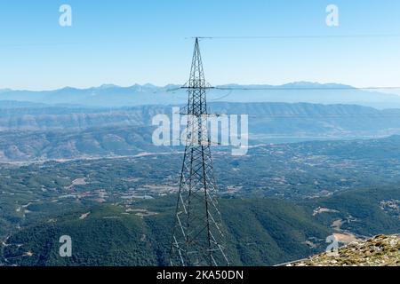 Ein Stromübertragungsturm oder Pylon auf dem Gipfel des Berges. Stockfoto