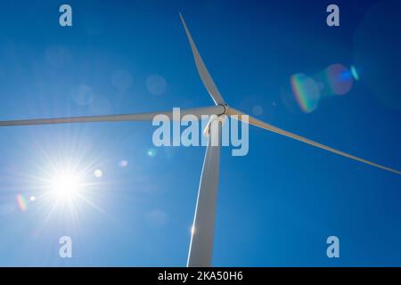 Nahaufnahme der rotierenden Rotorblätter und des Kopfes einer Windenergieanlage. Stockfoto