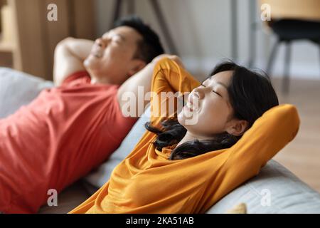 Entspanntes asiatisches Paar chillt zusammen zu Hause Stockfoto