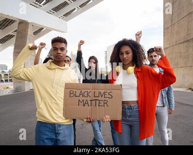 Eine Gruppe verschiedener junger Menschen, die gegen Rassismus protestieren und ein Zeichen halten, das sagt, dass schwarze Leben wichtig sind Stockfoto
