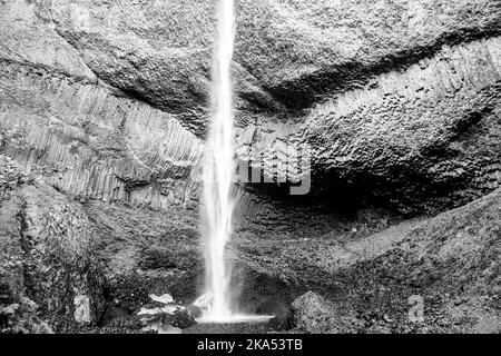 Latourell Wasserfall in Oregon, mit grauer strukturierter Felswand und Moos, die am Ende des Wasserfalls wachsen. Stockfoto