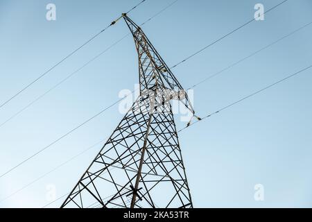 Ein Blick auf einen Stromübertragungsturm von der Basis nach oben. Stockfoto