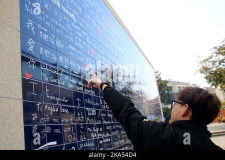 SUZHOU, CHINA - 31. OKTOBER 2022 - die Bürger sehen und posieren für Fotos neben der Französischen Liebesmauer im Ligongdi Kultur- und Kreativblock von Suzho Stockfoto