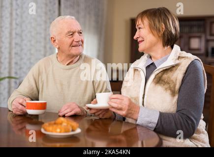 Porträt eines älteren Paares, das am Tisch sitzt und Tee trinkt Stockfoto