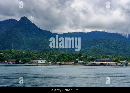 Der Hafen von Alotau am Fuße des Dschungels bedeckte die Owen Stanley Range. Milne Bay, Papua-Neuguinea Stockfoto