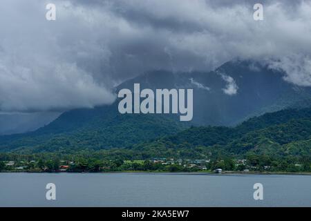 Der Hafen von Alotau am Fuße des Dschungels bedeckte die Owen Stanley Range. Milne Bay, Papua-Neuguinea Stockfoto