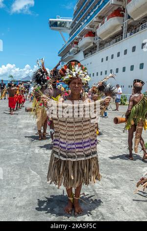 Einheimische Tänzer in traditioneller Tracht begrüßen die Ankunft eines Kreuzschiffs, Alotau, Provinz Milne Bay, Papua-Neuguinea Stockfoto