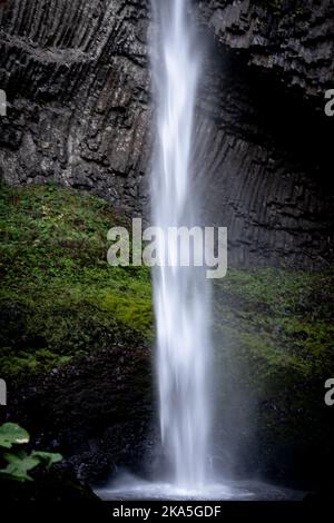 Latourell Wasserfall in Oregon, mit grauer strukturierter Felswand und Moos, die am Ende des Wasserfalls wachsen. Stockfoto