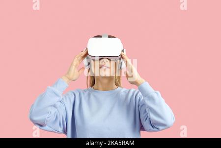 Frau isoliert auf farbigem Hintergrund virtuelle Realität in innovativer VR-Brille erleben Stockfoto