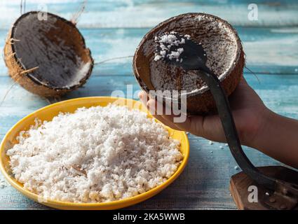 Muscheln und Boden mit Schaber auf einem blauen Holztisch Stockfoto