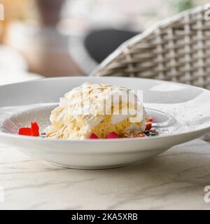 Meringuerolle mit Erdbeeren, Blaubeeren, Himbeeren und Preiselbeeren. Dessert mit frischen Beeren auf dem Tisch dekoriert. Stockfoto
