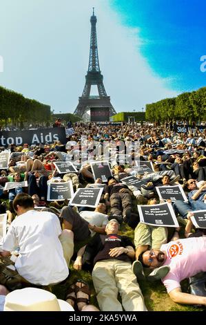 PARIS, Frankreich - große Menschenmenge von Demonstranten, die niederlegen, AIDS-Demonstration, um mehr Mittel für internationale Fonds auf dem Rasen Champs-de-Mars, Park in der Nähe des Eiffelturms zu fordern Stockfoto