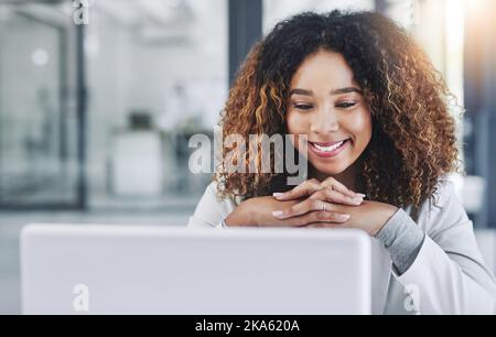 Shes ein beschäftigter Unternehmer. Eine junge Geschäftsfrau, die in einem Büro an einem Laptop arbeitet. Stockfoto