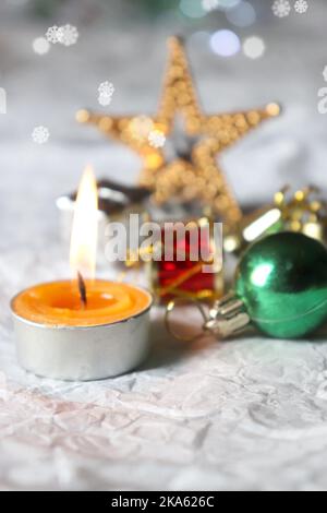 Beleuchtete Teelicht-Kerze/Weihnachtsdekorationen/Bokeh/weißer Hintergrund/Kopierbereich Stockfoto
