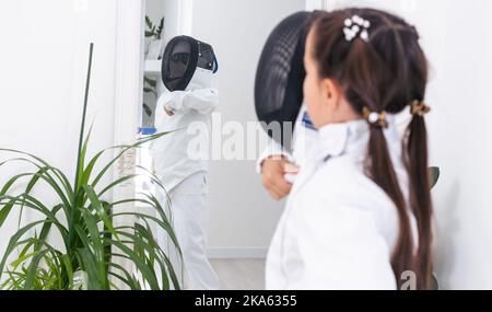 Kleines Mädchen in einem Fechtanzug Stockfoto