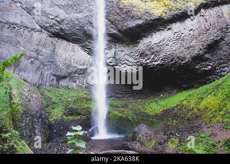 Latourell Wasserfall in Oregon, mit grauer strukturierter Felswand und Moos, die am Ende des Wasserfalls wachsen. Stockfoto