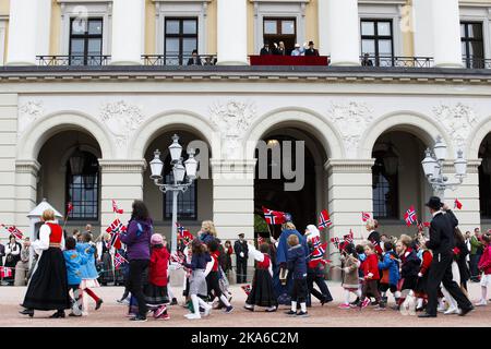 Oslo, Norwegen 20150517. Kinderparade und Feier am 17.. Mai, dem norwegischen Tag der Verfassung am Karl Johans Tor und dem Schlossplatz in Oslo. Schulen mit ihren Spruchbändern und Kinder mit Fahnen stehen vor dem Schloss. Die königliche Familie befindet sich auf dem Balkon. Foto: Heiko Junge / NTB scanpix Stockfoto