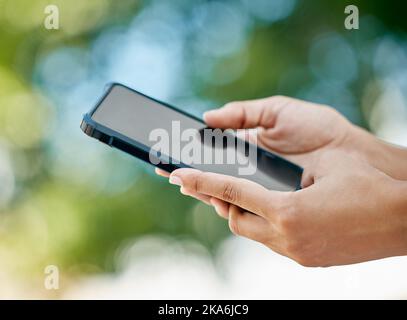 Nachbau, Telefon und Nahaufnahme der Hände in der Natur mit leerem, leerem und schwarzem Bildschirm. Technologie, Kommunikation und Person, die Smartphone im Freien hält Stockfoto