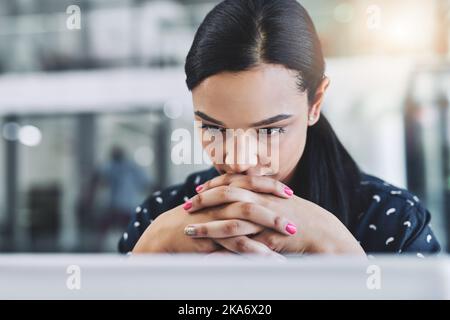 Wie werde ich das regeln? Eine attraktive junge Geschäftsfrau in ihrem Büro. Stockfoto