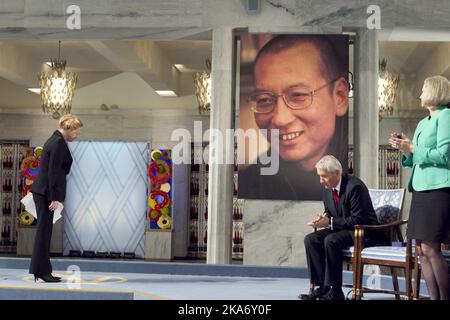 Oslo, 20170713: Der Friedensnobelpreisträger 2010, Liu Xiaobo, ist verstorben. File photo from December 10. 2010: Die Schauspielerin Liv Ullmann begrüßt das Porträt von Liu Xiaobo bei der Verleihung des Friedensnobelpreises im Rathaus von Oslo am Freitag. Der Vorsitzende des Nobelkomitees Thorbjørn Jagland und das Ausschussmitglied Kaci Kullmann Five (rechts). Der Friedensnobelpreis 2010 wird an den chinesischen Dissidenten Liu Xiaobo verliehen. Xiaobo wird während der Zeremonie von einem leeren Stuhl auf dem Podium vertreten, da er in China inhaftiert ist. POOL. Foto: Heiko Junge / NTB scanpix Stockfoto