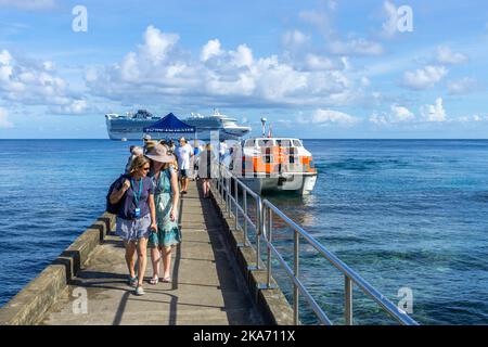 Passagiere, die durch kleine Ausschreibungen des vor Kiriwina Island, Papua-Neuguinea verankerten Kreuzfahrtschiffes an den Anlegesteg gebracht werden Stockfoto