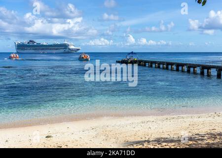 Passagiere, die durch kleine Ausschreibungen des vor Kiriwina Island, Papua-Neuguinea verankerten Kreuzfahrtschiffes an den Anlegesteg gebracht werden Stockfoto