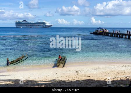 Passagiere, die durch kleine Ausschreibungen des vor Kiriwina Island, Papua-Neuguinea verankerten Kreuzfahrtschiffes an den Anlegesteg gebracht werden Stockfoto