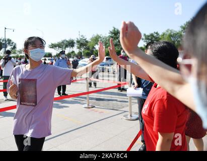 (200707) -- PEKING, 7. Juli 2020 (Xinhua) -- ein Examinee klatscht mit einem Lehrer vor einem Prüfungsort in Peking, der Hauptstadt Chinas, am 7. Juli 2020. MIT DEN XINHUA-SCHLAGZEILEN VOM 7. JULI (Xinhua/Ju Huanzong) Stockfoto