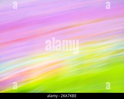 Über dem Hügel erhebt sich die farbenfrohe, dynamische und abstrakte Sonne in Pink und Orange. Stockfoto