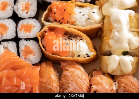 Verschiedene Sushi-Nigiri- und Maki-Sets. Eine Auswahl an japanischem Sushi mit Thunfisch, Krabben, Lachs und Brötchen. Stockfoto