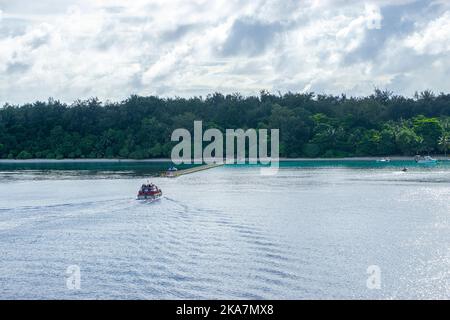 Passagiere, die durch kleine Ausschreibungen des vor den Konfliktinseln in Papua-Neuguinea verankerten Kreuzfahrtflugzeugs an den Anlegesteg gebracht werden Stockfoto