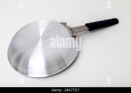 Eine antihaftbeschichtete Bratpfanne aus Edelstahl, die auf einen schlichten weißen Hintergrund geschossen wurde. Stockfoto