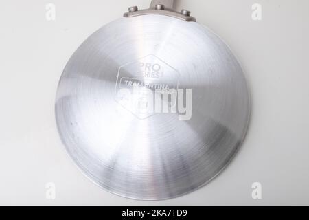 Eine antihaftbeschichtete Bratpfanne aus Edelstahl, die auf einen schlichten weißen Hintergrund geschossen wurde. Stockfoto