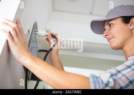 Aus der Sicht einer Arbeiterin, die den Stecker in die Steckdose steckt Stockfoto