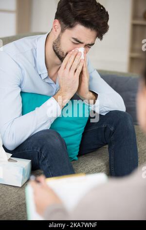 Ein trauriger Mann, der einen Psychologen besucht Stockfoto