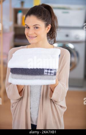 Frau mit frisch gereinigten Handtüchern Stockfoto
