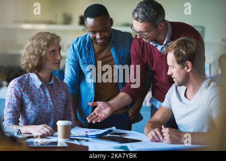 Die Kreativabteilung tut, was sie am besten kann. Eine vielfältige Gruppe von Geschäftsleuten, die in einem modernen Büro an einem Projekt mitarbeiten. Stockfoto
