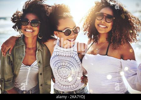 Drei Freunde haben sich an einem sonnigen Tag am Strand amüsieren können. Stockfoto